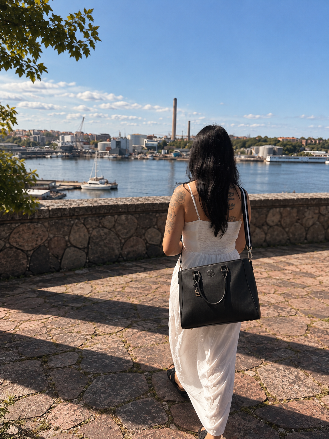 The Signature Bag i Midnight Black buren över axeln, för en känsla av väskans storlek